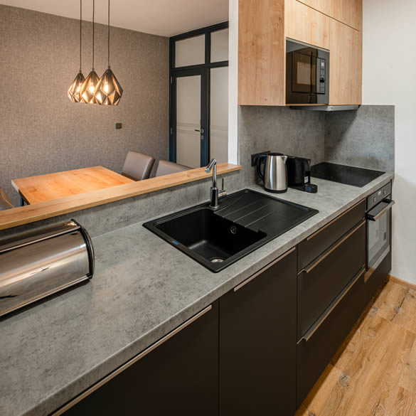 Kuchyňská linka a jídelní stůl modernizovaného apartmánu s 1 ložnicí v Landal Marina Lipno