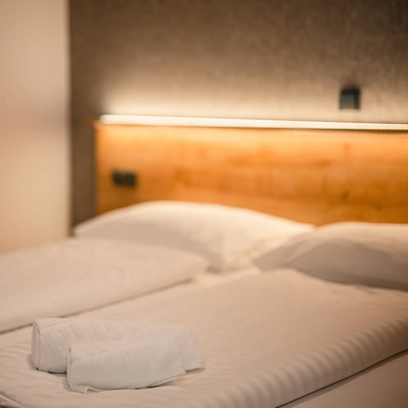 Postele s osvětlenou pelestí v ložnici modernizovaného apartmánu v Landal Marina Lipno