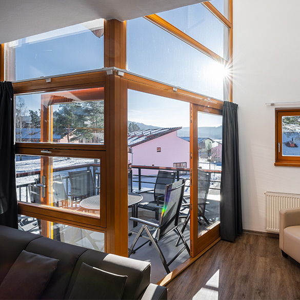 Výhled z obývacího pokoje na balkon s posezením
