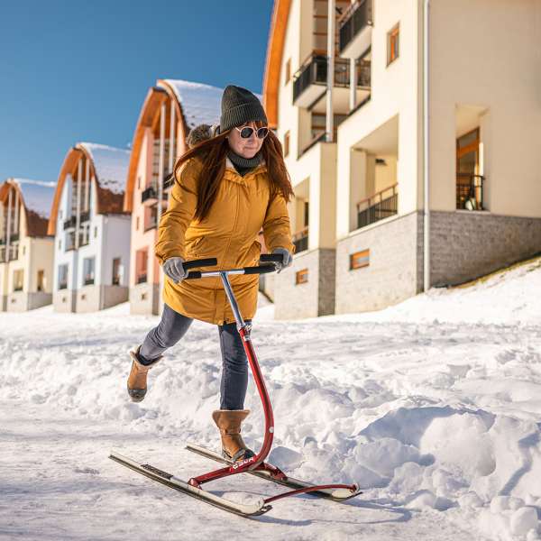 Paní jede na ledoběžkách, po stezce před apartmány Landal Marina Lipno