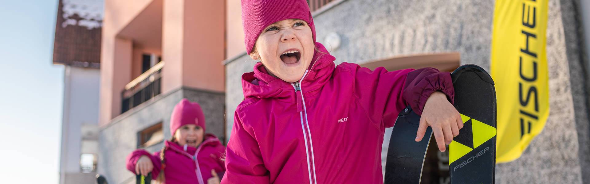 Děti s lyžemi před apartmány Marina Lipno