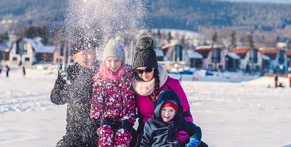 Rodina na zamrzlém jezeře Lipno před resortem Landal Marina Lipno